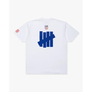 Areena Design <p>FIFA UNDEFEATED X US SOCCER LOGO S/S TEE delivers graphic fan style with easy everyday wearability, inspired by U.S. Soccer supporter culture and global football culture. A versatile short-sleeve tee for match days, streetwear looks, travel and everyday casual wear.</p> FIFA UNDEFEATED X US SOCCER LOGO S/S TEE <p>FIFA UNDEFEATED X US SOCCER LOGO S/S TEE delivers graphic fan style with easy everyday wearability, inspired by U.S. Soccer supporter culture and global football culture. A versatile short-sleeve tee for match days, streetwear looks, travel and everyday casual wear.</p>