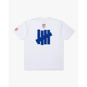 Areena Design <p>UNDEFEATED X US SOCCER LOGO T-SHIRT delivers graphic fan style with easy everyday wearability, inspired by U.S. Soccer supporter culture. A versatile t-shirt for match days, streetwear looks, travel and everyday casual wear.</p> UNDEFEATED X US SOCCER LOGO T-SHIRT <p>UNDEFEATED X US SOCCER LOGO T-SHIRT delivers graphic fan style with easy everyday wearability, inspired by U.S. Soccer supporter culture. A versatile t-shirt for match days, streetwear looks, travel and everyday casual wear.</p>