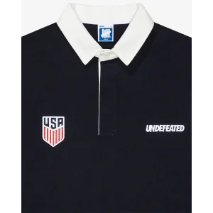 Areena Design <p>UNDEFEATED X US SOCCER RUGBY SHIRT delivers graphic fan style with easy everyday wearability, inspired by U.S. Soccer supporter culture. A versatile rugby shirt for match days, streetwear looks, travel and everyday casual wear.</p> UNDEFEATED X US SOCCER RUGBY SHIRT <p>UNDEFEATED X US SOCCER RUGBY SHIRT delivers graphic fan style with easy everyday wearability, inspired by U.S. Soccer supporter culture. A versatile rugby shirt for match days, streetwear looks, travel and everyday casual wear.</p>